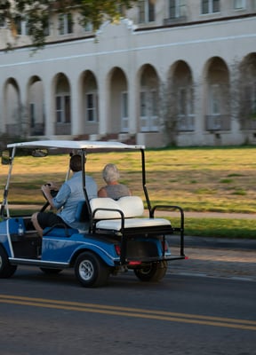 Golf cart driving down a sunny street