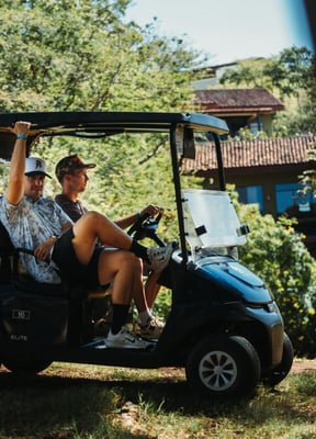Two friends riding a golf cart